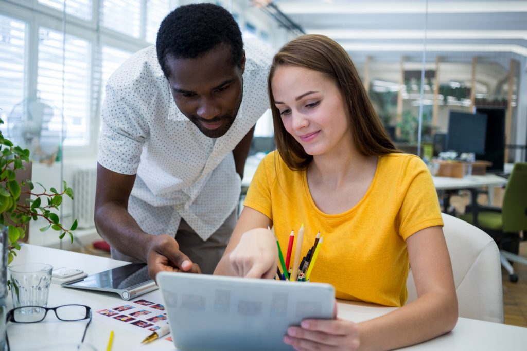 Graphistes masculins et féminins discuter sur tablette numérique