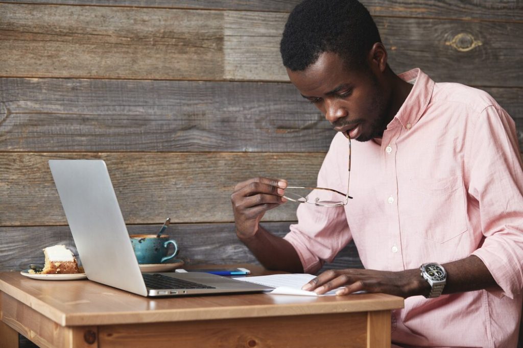 Jeune homme afro americain utilisant un ordinateur portable